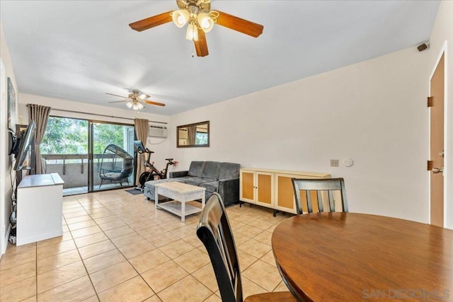 tiled dining room featuring a wall unit AC and ceiling fan