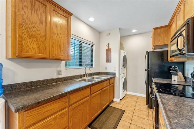 kitchen with stacked washer / drying machine, electric range, sink, and light tile patterned flooring