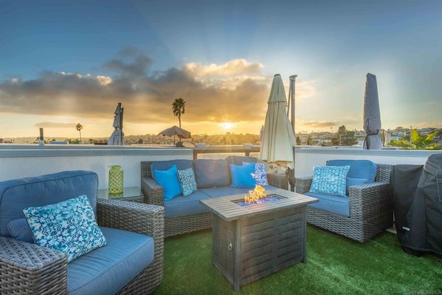 patio terrace at dusk featuring an outdoor living space with a fire pit