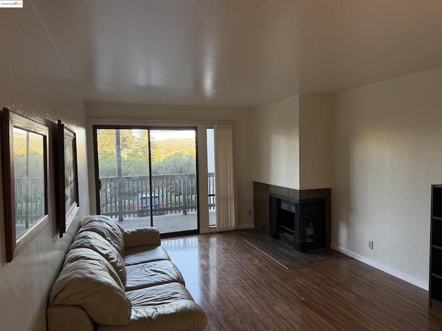 unfurnished living room featuring a multi sided fireplace and dark hardwood / wood-style flooring