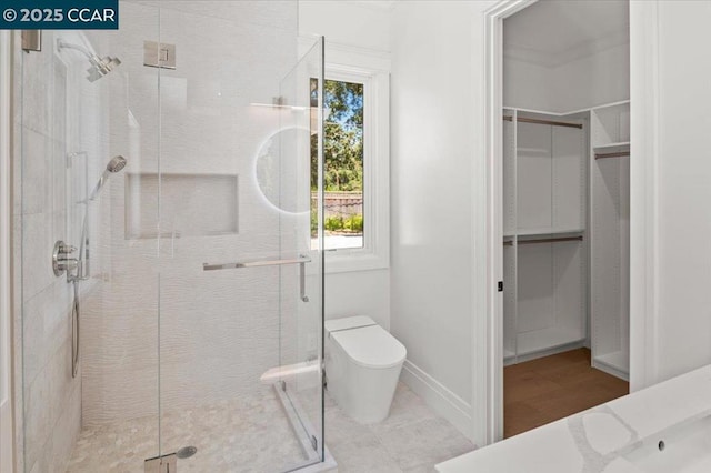 bathroom featuring toilet and a shower with shower door