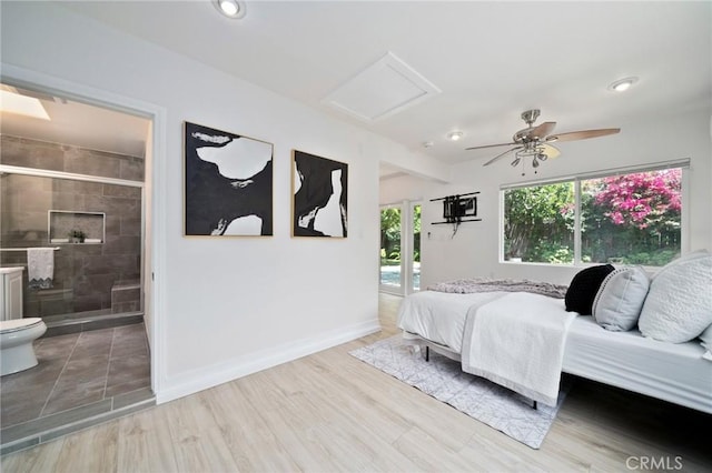 bedroom featuring ceiling fan, ensuite bathroom, and light hardwood / wood-style flooring