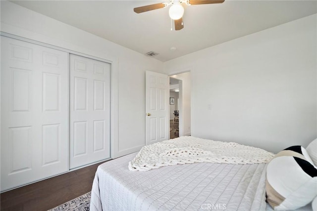 bedroom with dark hardwood / wood-style flooring, a closet, and ceiling fan