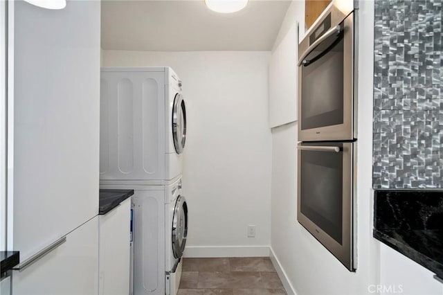 washroom featuring stacked washer and clothes dryer