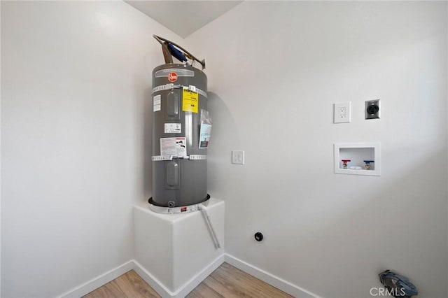 laundry room with electric dryer hookup, secured water heater, hookup for a washing machine, and hardwood / wood-style flooring