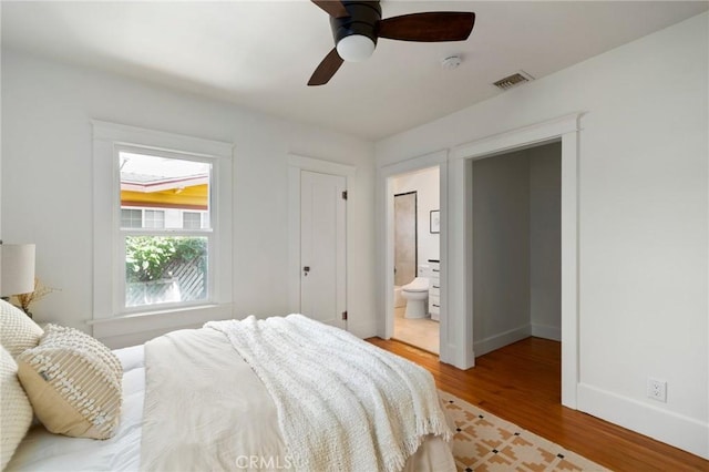 bedroom with ceiling fan, connected bathroom, and light hardwood / wood-style floors