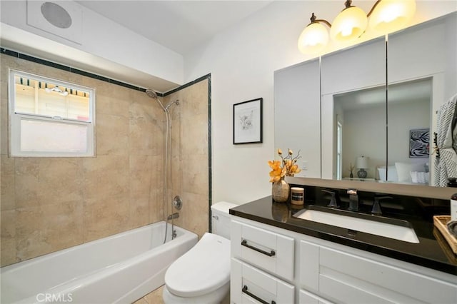 full bathroom with vanity, tiled shower / bath combo, and toilet