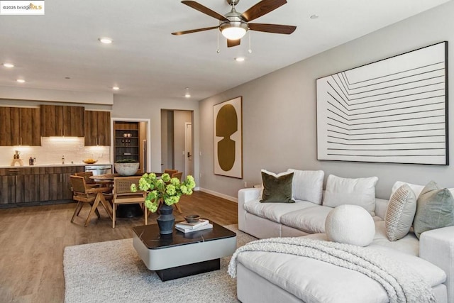 living room with light hardwood / wood-style floors and ceiling fan