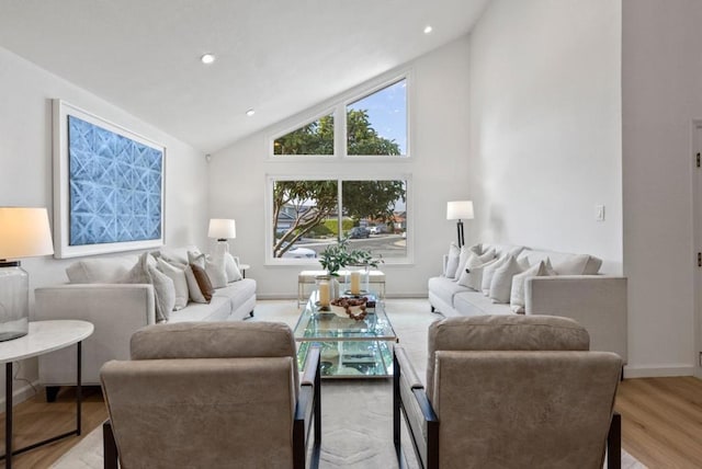 living room with high vaulted ceiling and light wood-type flooring