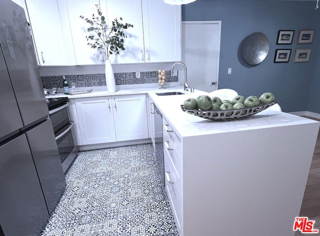 kitchen featuring white cabinetry, stainless steel appliances, sink, and tasteful backsplash