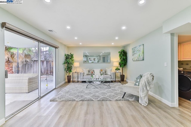 living room featuring washer / clothes dryer and light hardwood / wood-style flooring