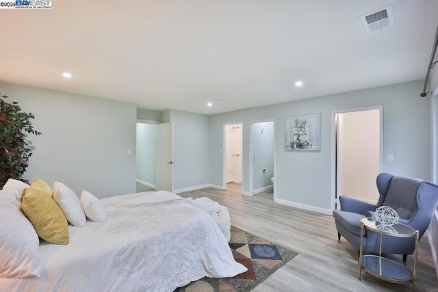 bedroom featuring ensuite bathroom and light hardwood / wood-style floors