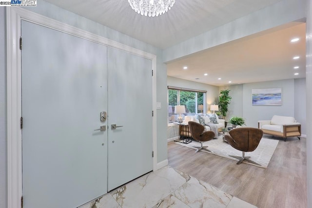 entryway featuring an inviting chandelier and light wood-type flooring