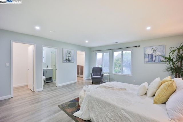 bedroom with light hardwood / wood-style floors and ensuite bathroom