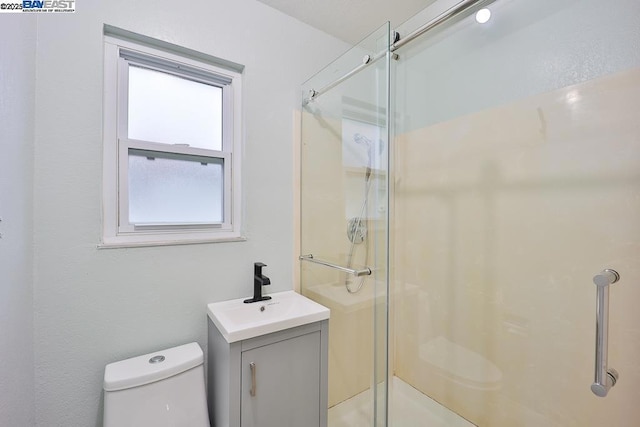 bathroom featuring vanity, an enclosed shower, and toilet