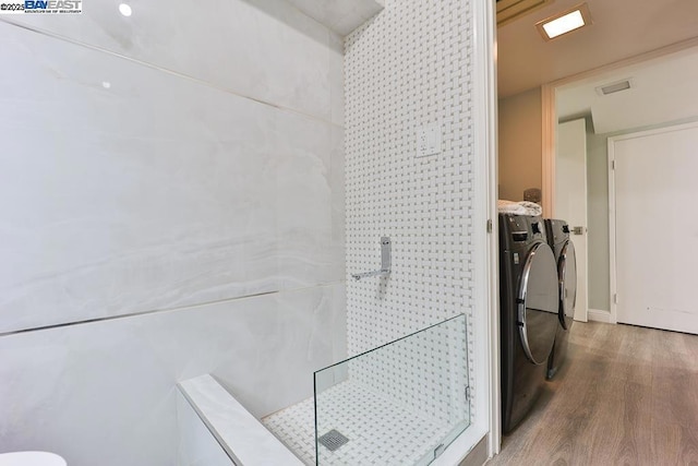 laundry room with hardwood / wood-style flooring and washer and clothes dryer