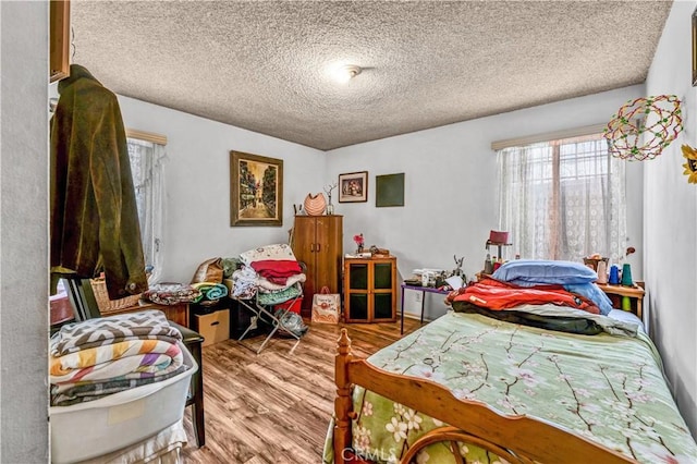 bedroom featuring hardwood / wood-style flooring and a textured ceiling