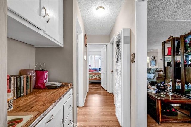 hallway featuring a textured ceiling and light wood-type flooring