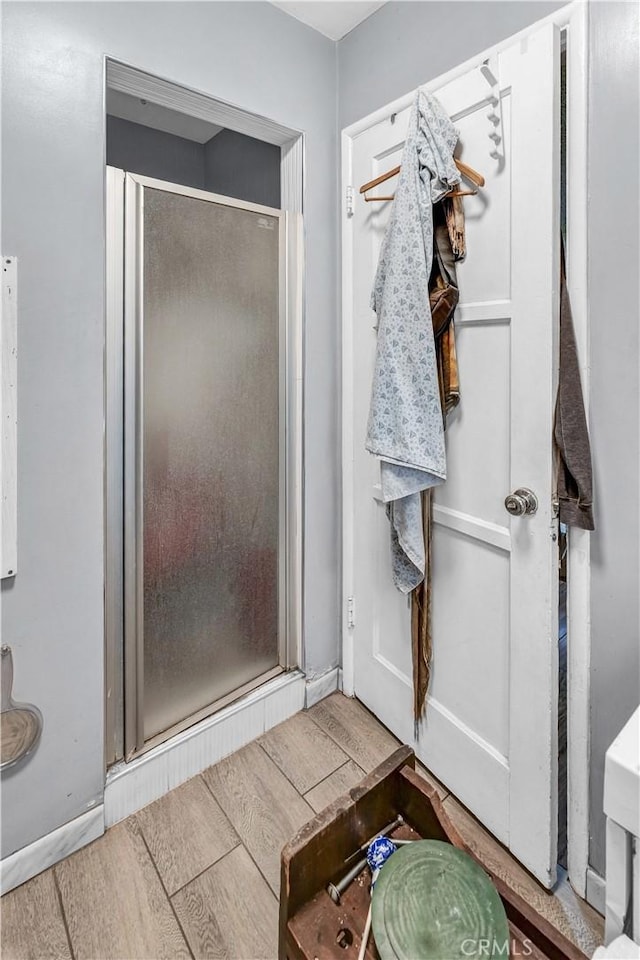 bathroom with hardwood / wood-style flooring and walk in shower