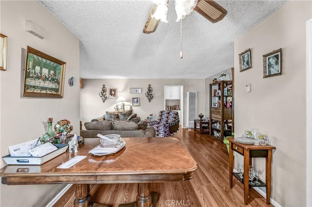 living room with ceiling fan, wood-type flooring, and a textured ceiling