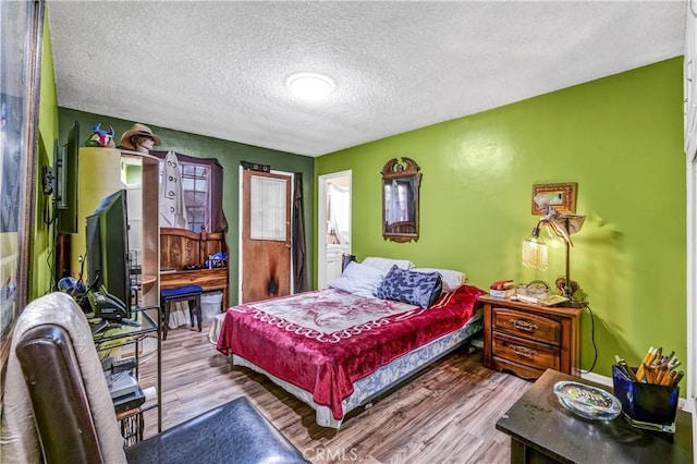 bedroom featuring light hardwood / wood-style flooring and a textured ceiling