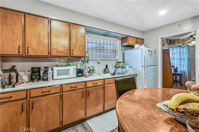 kitchen with white appliances and light hardwood / wood-style flooring