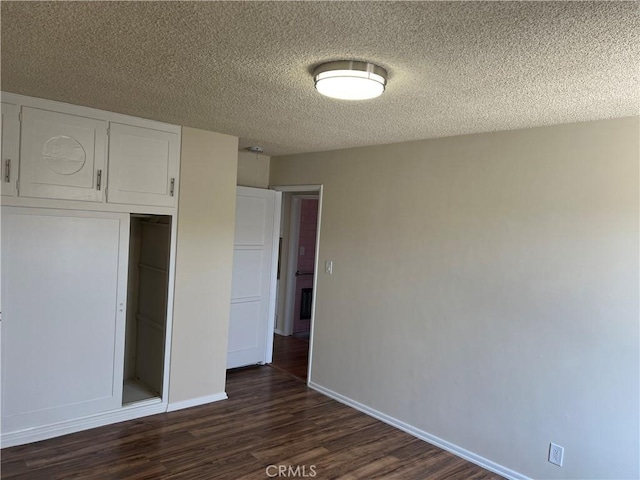 2441 W Repetto Ave, Montebello, CA 90640 - unfurnished bedroom with dark wood-style flooring, a textured ceiling, baseboards, and a closet