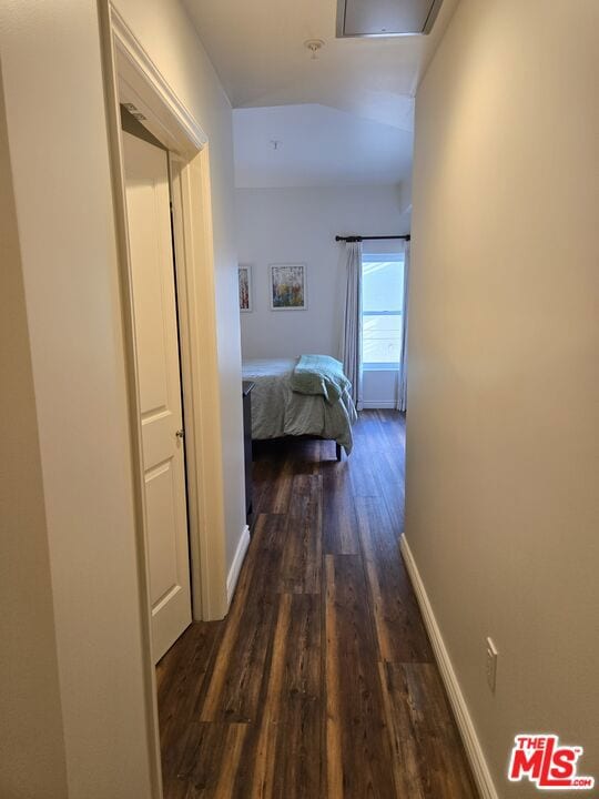 corridor featuring lofted ceiling and dark wood-type flooring