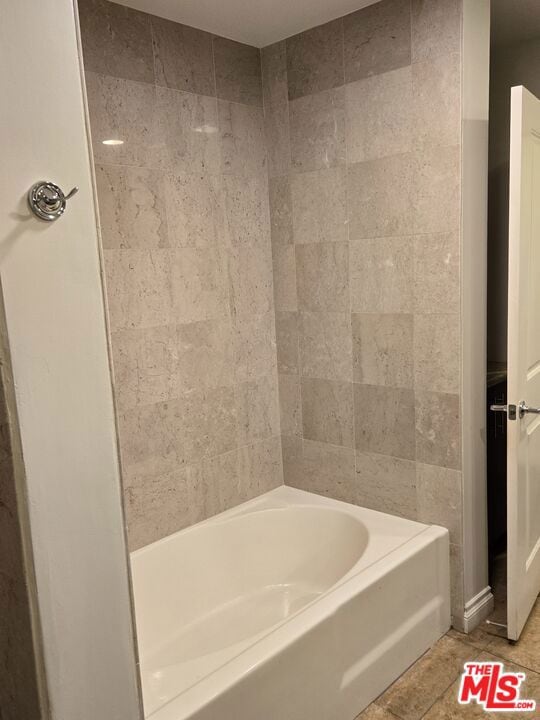 bathroom with tile patterned flooring and a tub