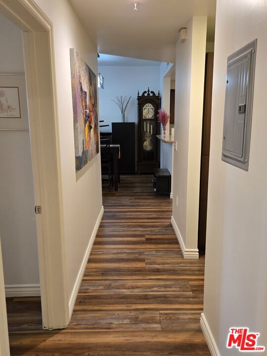 hallway featuring dark wood-type flooring and electric panel