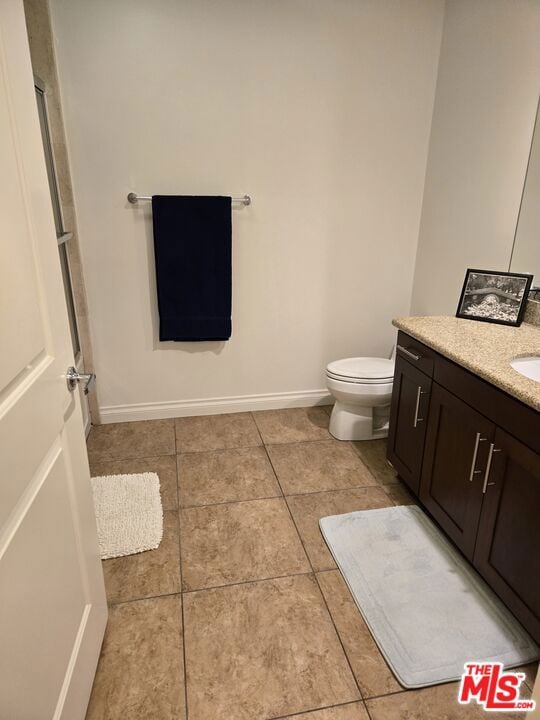 bathroom featuring vanity, toilet, and tile patterned flooring