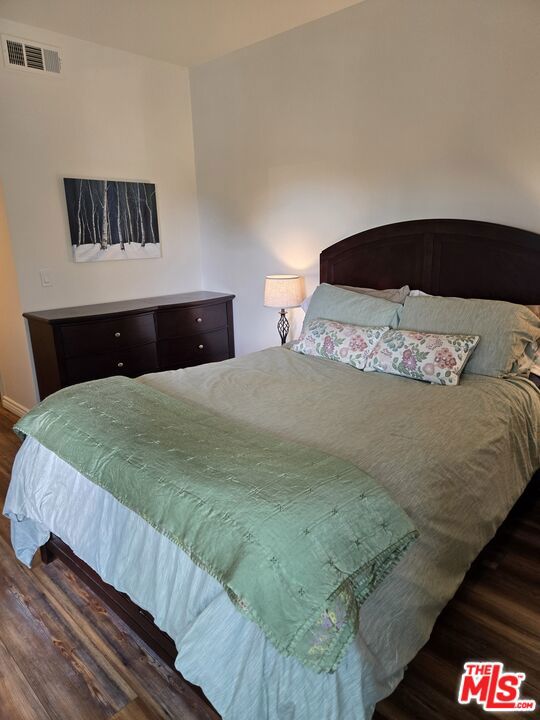 bedroom with dark wood-type flooring