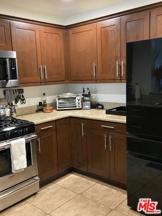 kitchen featuring appliances with stainless steel finishes and light tile patterned floors