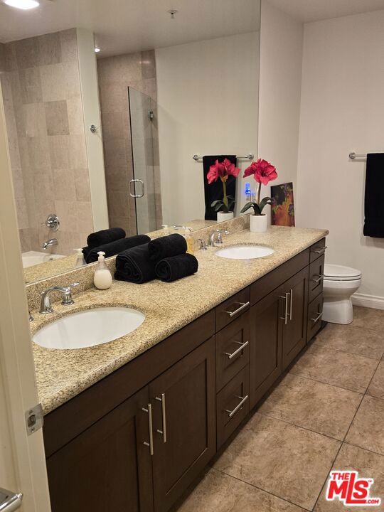 bathroom with vanity, an enclosed shower, tile patterned floors, and toilet