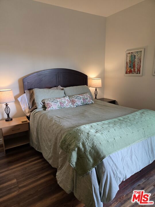 bedroom with dark hardwood / wood-style flooring