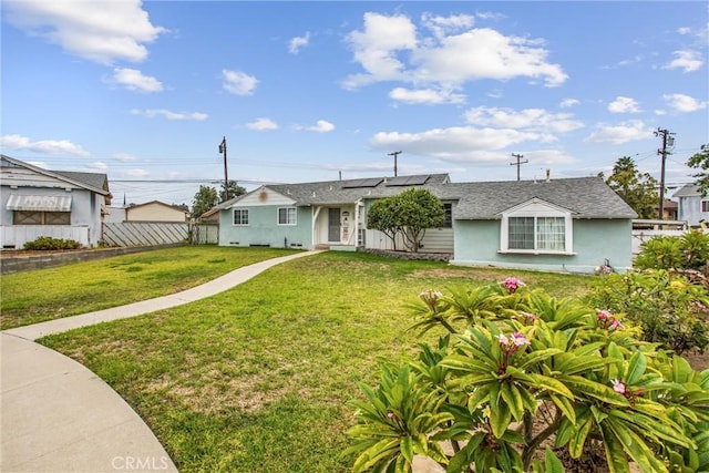 view of front of property with a front lawn and solar panels