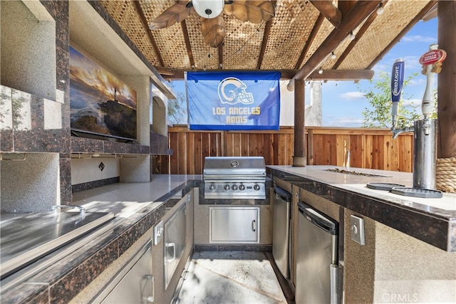 view of patio featuring fence, grilling area, and exterior kitchen