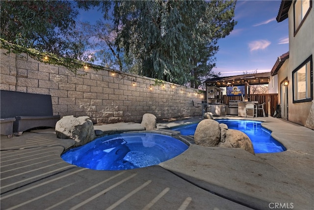 pool at dusk with a fenced in pool, a fenced backyard, an in ground hot tub, exterior kitchen, and a patio area