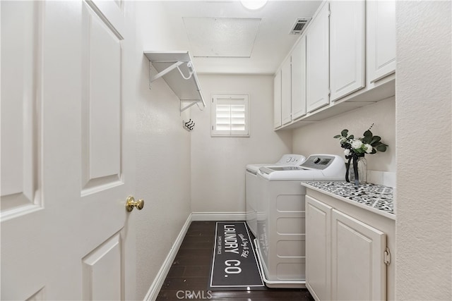 clothes washing area featuring dark wood-style flooring, visible vents, baseboards, washer and dryer, and cabinet space