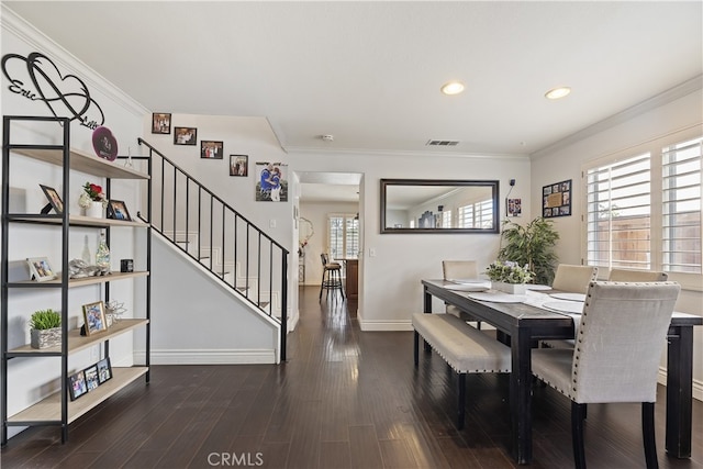 dining room featuring baseboards, visible vents, wood finished floors, stairs, and crown molding