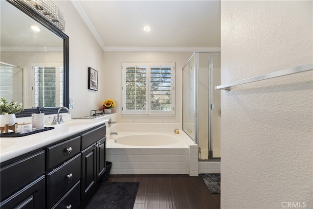 full bath featuring a garden tub, wood finished floors, a sink, ornamental molding, and a stall shower