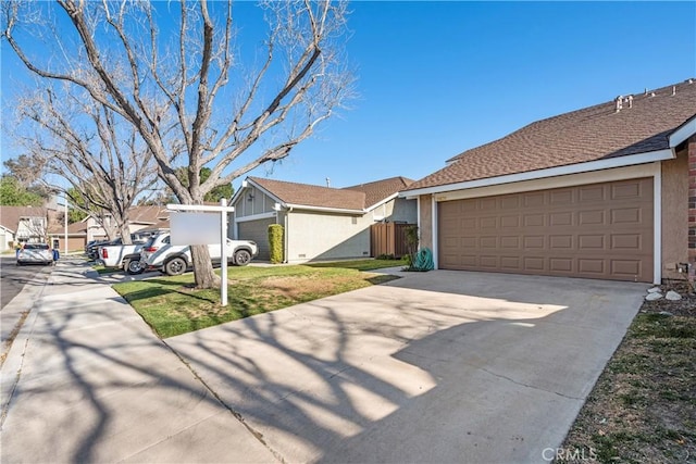 single story home featuring a residential view, concrete driveway, an attached garage, and stucco siding