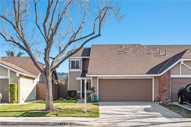 view of front facade with a garage, fence, concrete driveway, stucco siding, and a front lawn