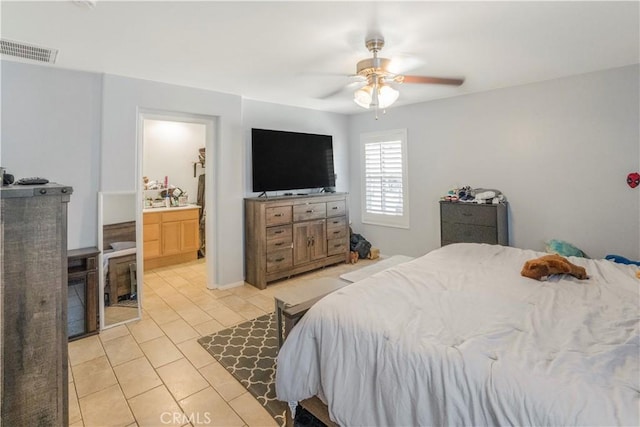 bedroom featuring a ceiling fan, visible vents, connected bathroom, and light tile patterned floors