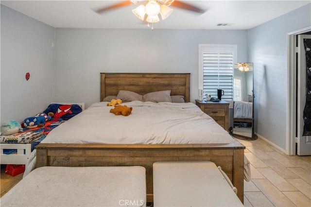 bedroom with a ceiling fan, visible vents, and baseboards