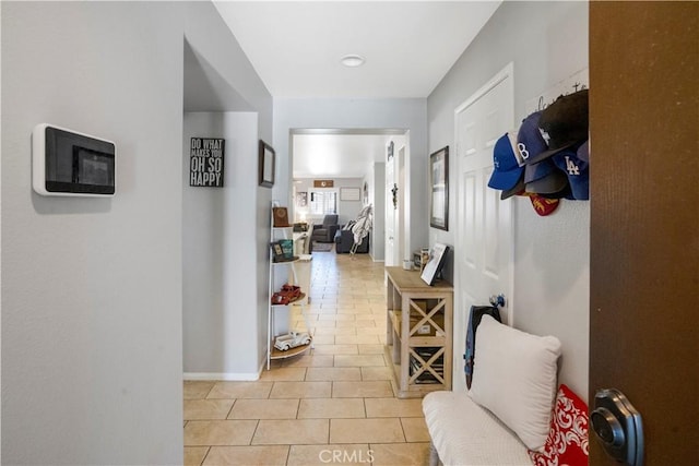 hallway with light tile patterned flooring and baseboards