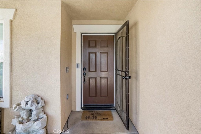 property entrance with stucco siding