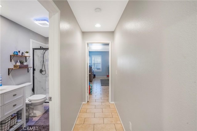 bathroom with a marble finish shower, baseboards, toilet, tile patterned flooring, and vanity