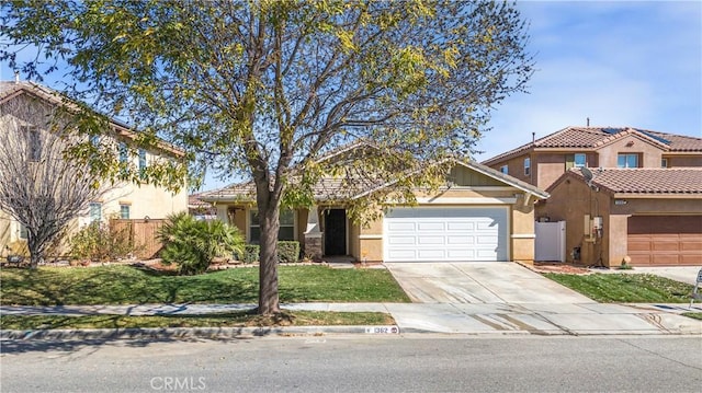 view of front of home featuring concrete driveway, an attached garage, fence, and stucco siding