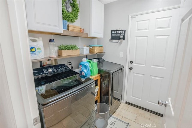 laundry room with cabinet space, light tile patterned floors, and separate washer and dryer